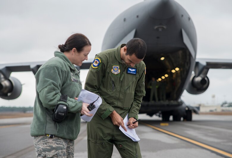 Staff Sgt. John Nolcox, the 6th Airlift Squadron aircrew member, completes paperwork for Staff. Sgt. Jessica Scharmen,  96th Logistics Readiness Squadron, prior to the Aerial operations Airmen uploading cargo to the C-17 Globemaster III Jan. 13 at Duke Field, Fla.  The LRS crew loaded more than 100,000 pounds of ammunition from the 7th Special Forces Group onto the aircraft during the upload.  (U.S. Air Force photo/Tech. Sgt. Cheryl Foster)