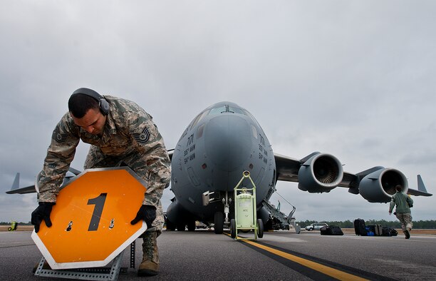Tech. Sgt. Dominic Wimsatt, 96th Logistics Readiness Squadron, places a ammunition type notification sign in front of the C-17 Globemaster III prior to uploading pallets onto the aircraft Jan. 13 at Duke Field, Fla.  The LRS crew loaded more than 100,000 pounds of ammunition from the 7th Special Forces Group onto the aircraft during the upload.  (U.S. Air Force photo/Tech. Sgt. Sam King)