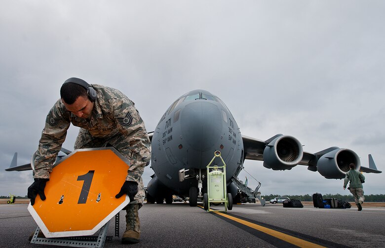 Tech. Sgt. Dominic Wimsatt, 96th Logistics Readiness Squadron, places a ammunition type notification sign in front of the C-17 Globemaster III prior to uploading pallets onto the aircraft Jan. 13 at Duke Field, Fla.  The LRS crew loaded more than 100,000 pounds of ammunition from the 7th Special Forces Group onto the aircraft during the upload.  (U.S. Air Force photo/Tech. Sgt. Sam King)