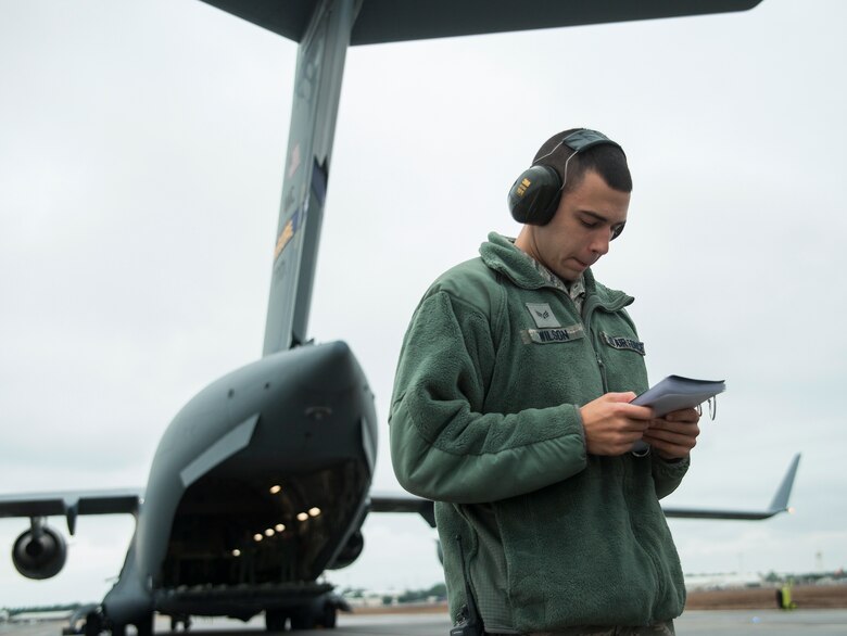 Senior Airman Joshua Wilson, 96th Logistics Readiness Squadron, verifies his checklist prior to the Aerial operations Airmen begin the uploading to the C-17 Globemaster III Jan. 13 at Duke Field, Fla.  The LRS crew loaded more than 100,000 pounds of ammunition from the 7th Special Forces Group onto the aircraft during the upload.  (U.S. Air Force photo/Tech. Sgt. Cheryl Foster)