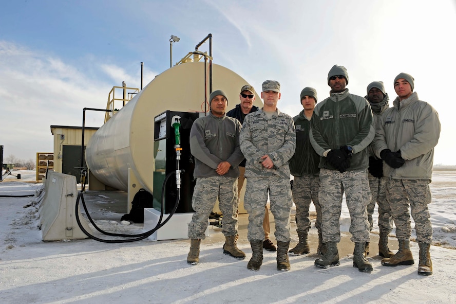 Airmen from the 5th Civil Engineer Squadron and 5th Logistics Readiness Squadron pose in front of the fuel station on Minot Air Force Base, N.D., Jan. 15, 2015. The project required the combined efforts of several base shops and will allow for a safer means of refueling for large equipment used on the flightline such as snow plows. (U.S. Air Force photo/Senior Airman Stephanie Morris)