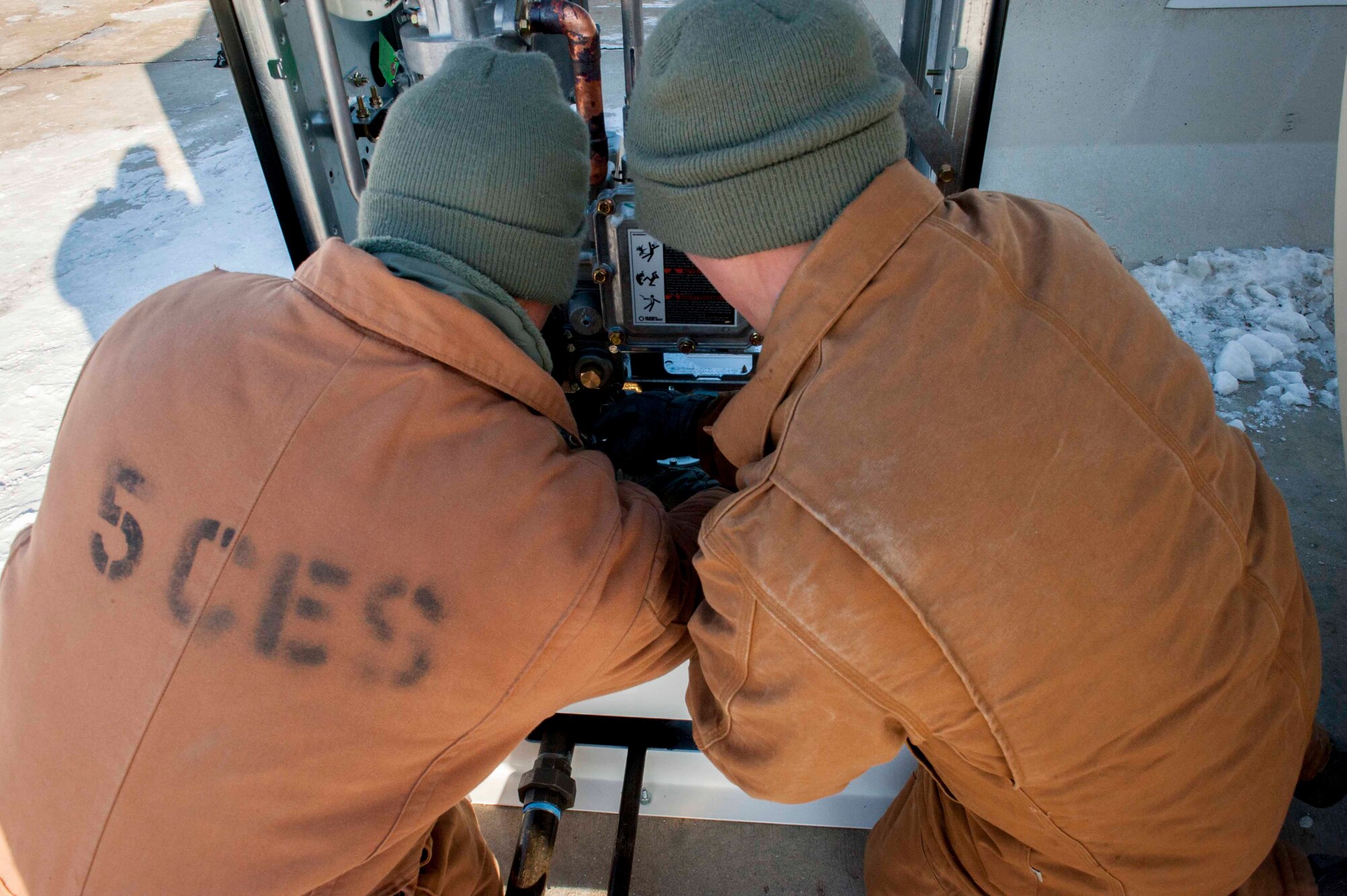 Airmen from the 5th Civil Engineer Squadron assemble a fuel dispenser on Minot Air Force Base, N.D., Jan. 13, 2015. The fuel station was recently built to ensure a more quick and efficient fueling for heavy equipment on the flightline. (U.S. Air Force photo/Airman 1st Class Sahara L. Fales)