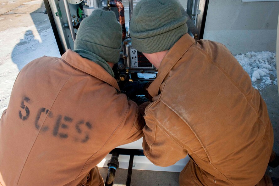 Airmen from the 5th Civil Engineer Squadron assemble a fuel dispenser on Minot Air Force Base, N.D., Jan. 13, 2015. The fuel station was recently built to ensure a more quick and efficient fueling for heavy equipment on the flightline. (U.S. Air Force photo/Airman 1st Class Sahara L. Fales)
