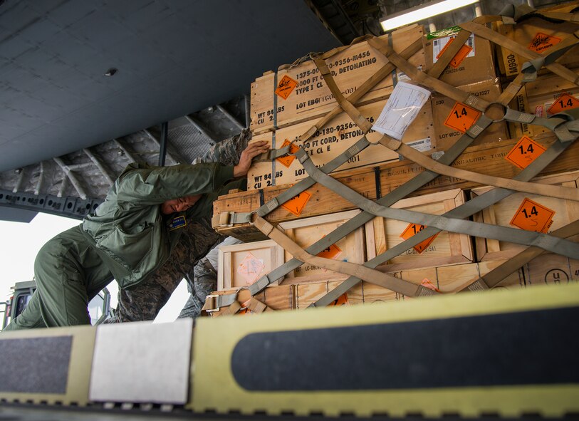 Staff Sgt. Kenneth Ng, 87th Security Forces Squadron, helps push an ammunition pallet on a 305th Air Mobility Wing C-17 Globemaster III Jan. 13, at Duke Field, Fla.  The aircrew picked up more than 100,000 pounds of ammunition from the 7th Special Forces Group during their stop.  (U.S. Air Force photo/Tech. Sgt. Sam King)