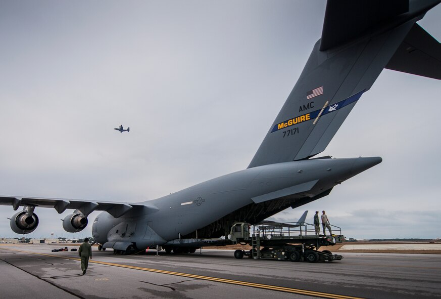 Aerial operations Airmen from the 96th Test Wing wait for the next pallet and a 305th Air Mobility Wing aircrew member walks toward his C-17 Globemaster III as a 1st Special Operations Wing C-130 passes overhead Jan. 13 at Duke Field, Fla. The aircrew picked up more than 100,000 pounds of ammunition from the 7th Special Forces Group during their stop.  (U.S. Air Force photo/Tech. Sgt. Sam King)