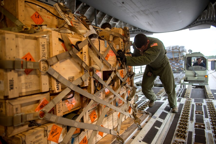 A member of the 305th Air Mobility Wing aircrew helps push a pallet of ammunition into a C-17 Globemaster III Jan. 13 at Duke Field, Fla.  The aircrew picked up more than 100,000 pounds of ammunition from the 7th Special Forces Group during their stop.  (U.S. Air Force photo/Tech. Sgt. Cheryl Foster)