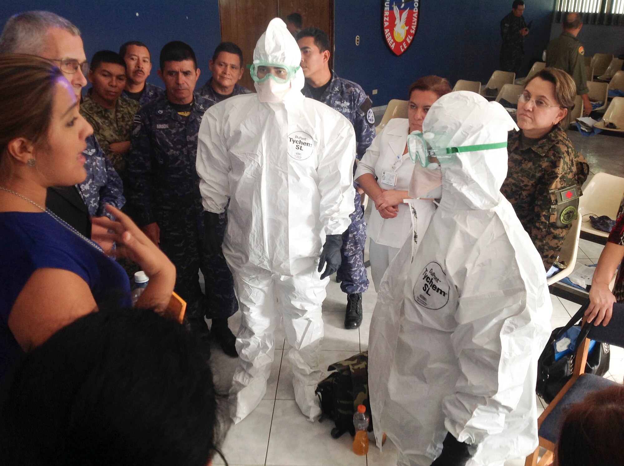 Medical professionals gather around during a demonstration on proper dawning techniques of personal protective equipment on Dec. 02, 2014, in El Salvador. Members of Air Forces Southern military training team were given the opportunity to teach approximately 100 individuals, from Latin American partner countries, a Defense Institute for Medical Operations train-the-trainer course focused on the Ebola virus. (Courtesy Photo)