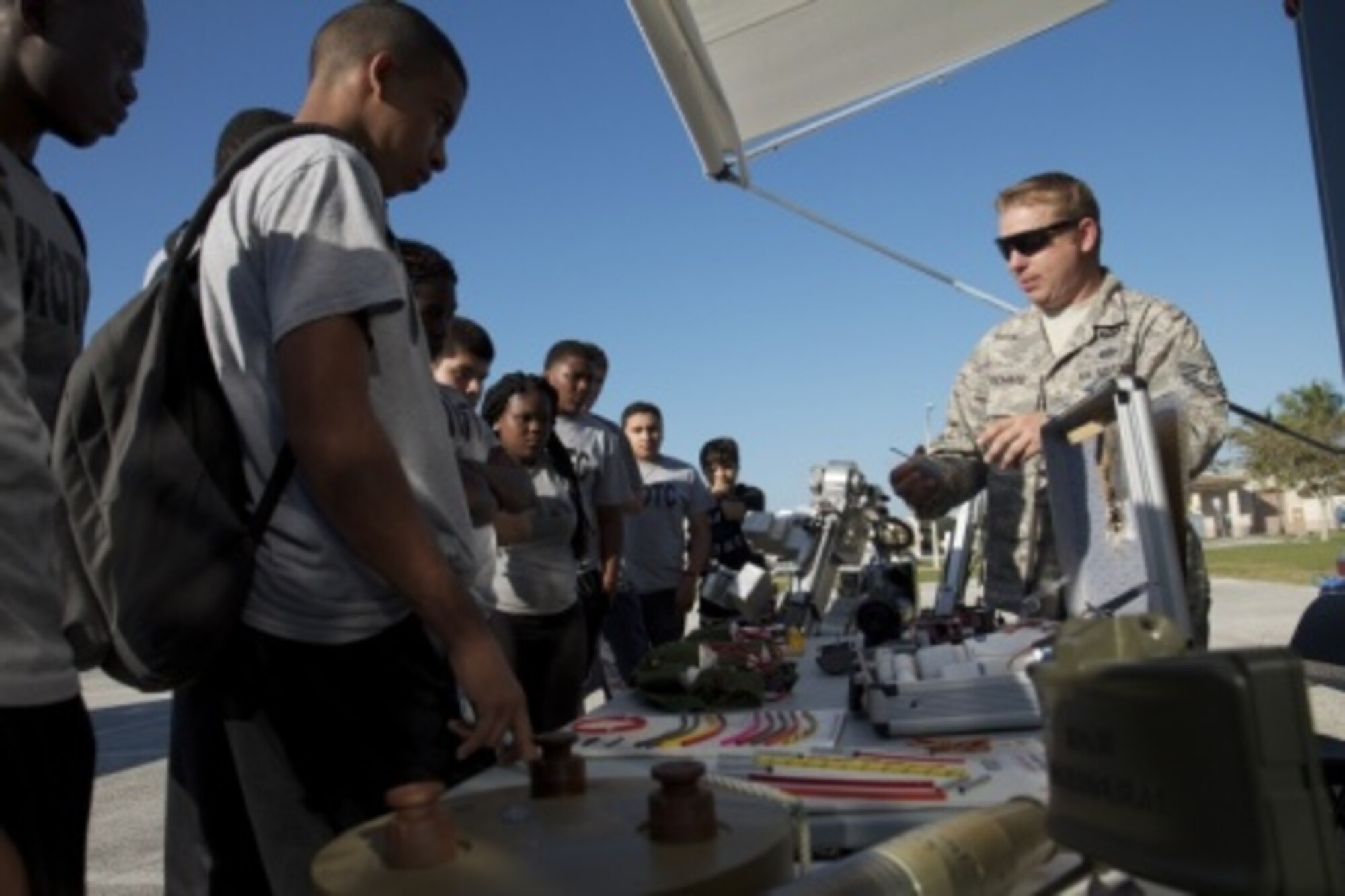 A U.S. Air Force explosive ordinance disposal (EOD) specialist displays examples of improvised explosive devices to high school students Jan. 22 during a two-day mentorship event as part of Special Operations Command South’s Military Assistance Program on Homestead Air Reserve Base, Fla. Participating units included service members from the 482nd Civil Engineer Squadron and EOD flight, the U.S. Coast Guard’s Maritime Safety Security Team Miami, and police officers with the Homestead Police Canine (K-9) Unit. (U.S. Army photo by Staff Sgt. Osvaldo Equite)