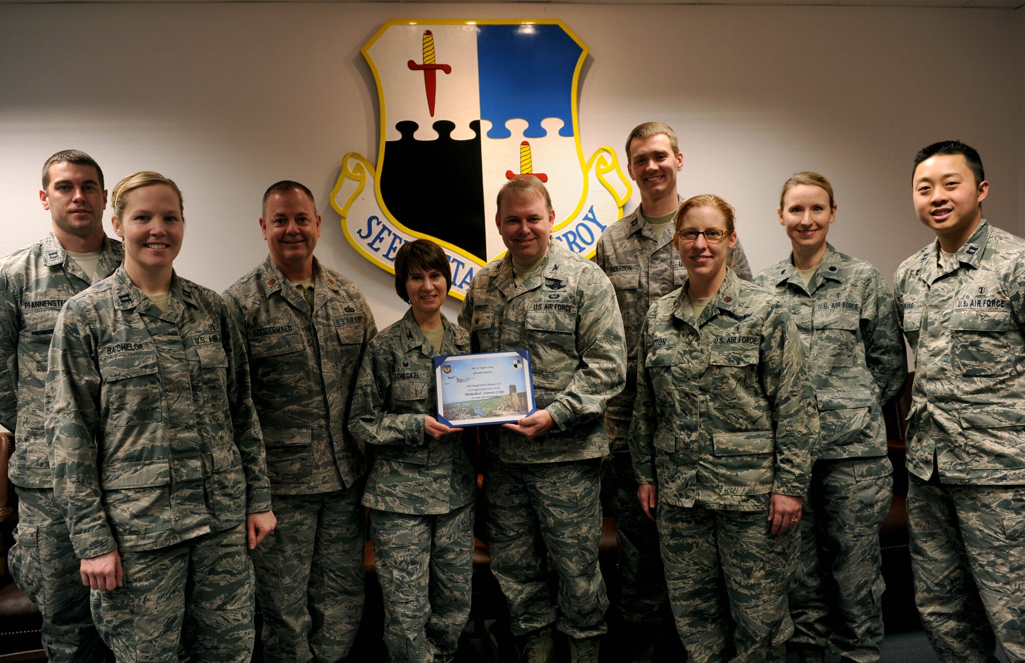 U.S. Air Force Col. Lars Hubert, 52nd Fighter Wing acting commander, center right, holds up a certificate designating Jan. 26-30, 2015, as Biomedical Science Corps Appreciation Week with U.S. Air Force Col. Jill Scheckel, 52nd Medical Group commander, center left, along with 52nd MDG Airmen in the wing conference room at Spangdahlem Air Base, Germany, Jan. 21, 2015. The BSC comprises career fields such as physical and occupational therapy; optometry; podiatry; physician assistants; audiology and speech pathology; clinical psychology; clinical social work; aerospace and operational physiology; dietetics; bioenvironmental engineers; public health; medical entomology; pharmacy; biomedical laboratory; healthcare facilities architects and engineers; and health and medical physics. (U.S. Air Force photo by Airman 1st Class Timothy Kim/Released)