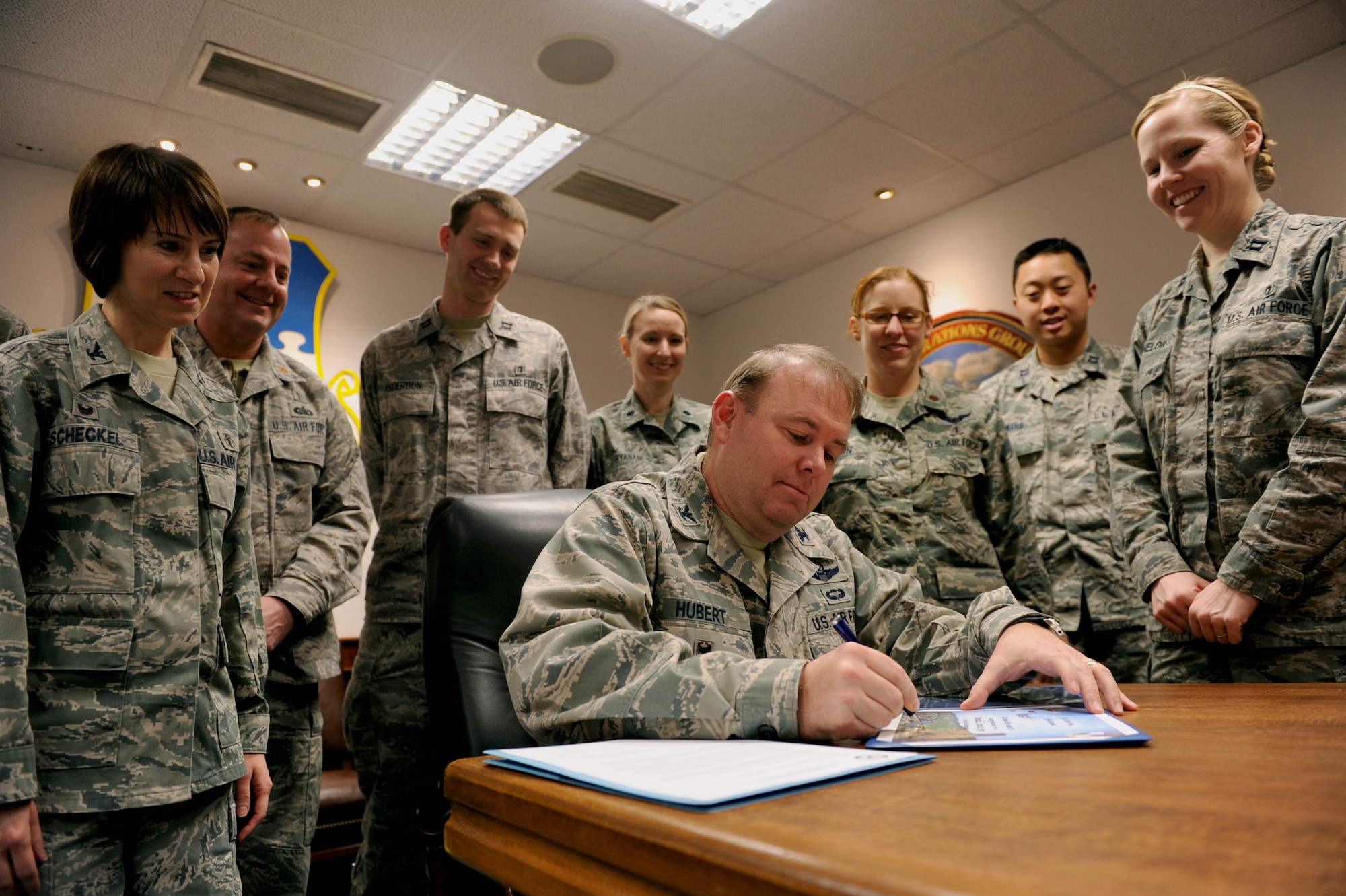 U.S. Air Force Col. Lars Hubert, 52nd Fighter Wing acting commander, signs a certificate and declaration surrounded by 52nd Medical Group Airmen in the wing conference room at Spangdahlem Air Base, Germany, Jan. 21, 2015. The proclamation designated Jan. 26-30, 2015 as Biomedical Science Corps Appreciation Week. (U.S. Air Force photo by Airman 1st Class Timothy Kim/Released)