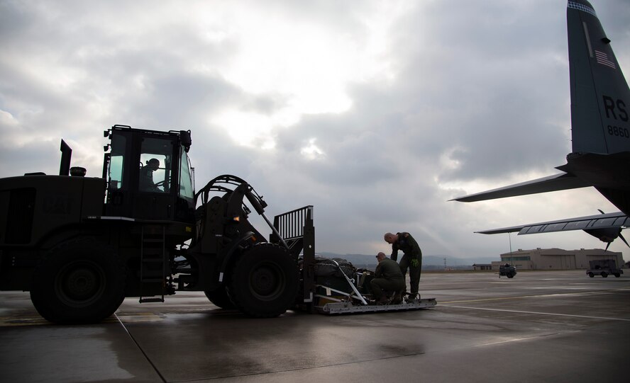 Loadmasters from the 37th Airlift Squadron ensure a bundle is properly secured prior to loading it into a C-130J Super Hercules at Ramstein Air Base, Germany, Jan. 20, 2015. Cargo loaded into an aircraft is carefully inspected by loadmasters and aerial delivery specialist to ensure the safety of the crew. (U.S. Air Force photo/Senior Airman Damon Kasberg)