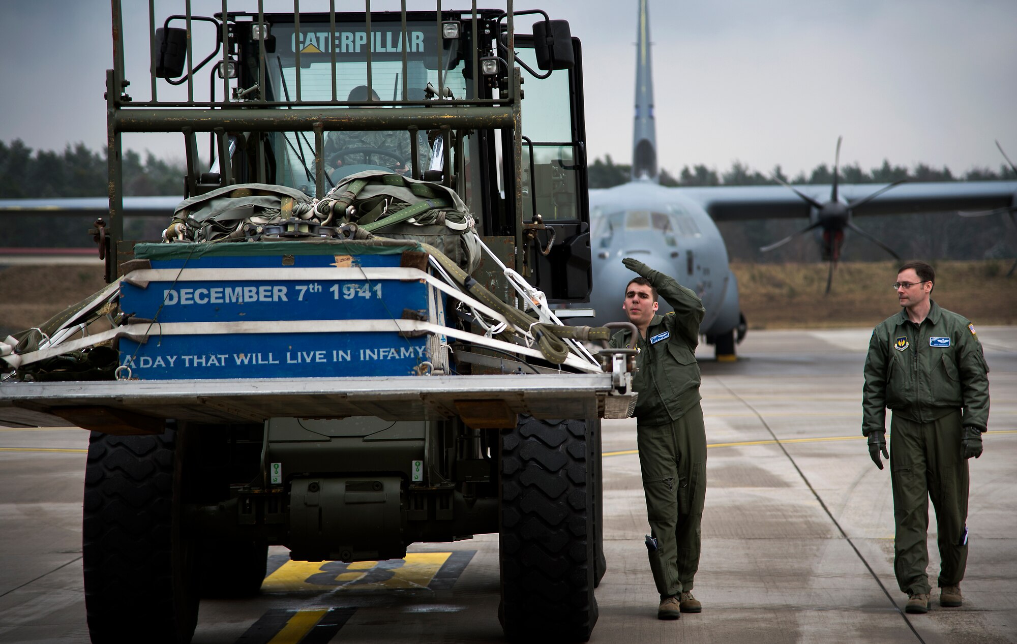 Airman 1st Class Dylan Arnt (center), 37th Airlift Squadron loadmaster, directs an Airman as she drives a forklift with cargo into a C-130J Super Hercules at Ramstein Air Base, Germany, Jan. 20, 2015. Cargo loaded into a C-130J must be carefully placed on the ramp to ensure no damage occurs to it or the aircraft. (U.S. Air Force photo/Senior Airman Damon Kasberg)