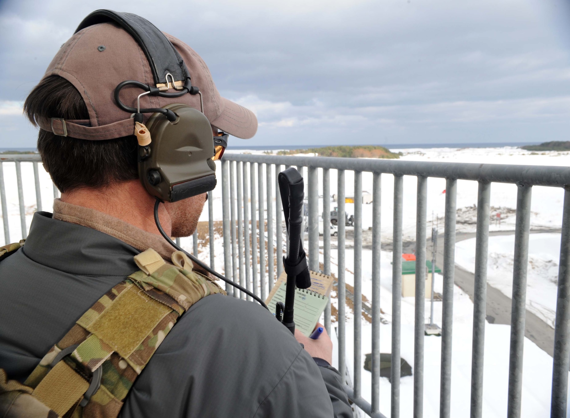 A U.S. Air Force joint terminal attack controller observes a target during precision-guided munitions training at Draughon Range outside Misawa Air Base, Japan, Jan. 13, 2015. The controllers communicated information to 35th Fighter Wing pilots from Misawa directing them in air strike operations during the first-ever laser guided munition training. Due to new software upgrades linked to the munitions systems, 14 FS pilots were able to drop laser-guided munitions for the first time here. (U.S. Air Force photo by Alyssa C. Wallace/Released)