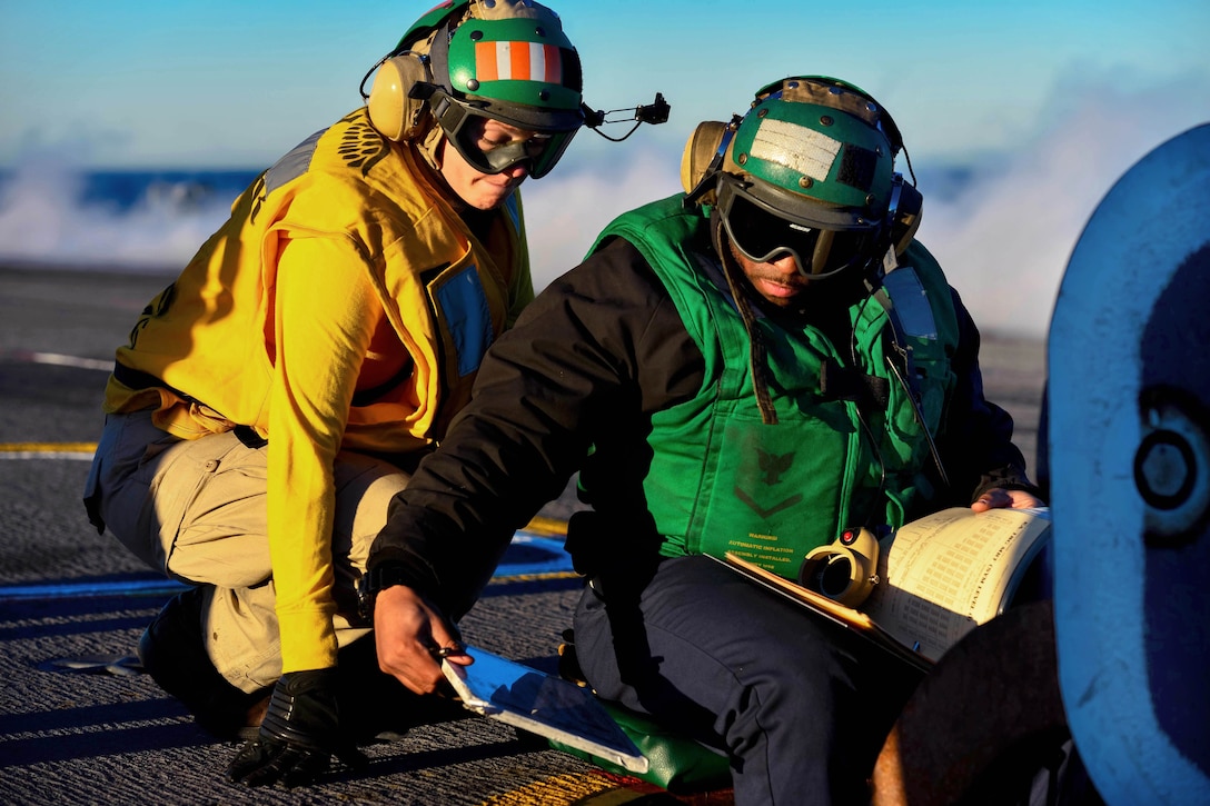 U.S. Navy Lt. Quincy Bowles, left, and U.S. Navy Petty Officer 3rd Class Jason Griffin review weight charts on the flight deck of the aircraft carrier USS John C. Stennis in the Pacific Ocean, Jan. 23, 2015. Griffin is an aviation boatswain's mate. The Stennis is currently undergoing an operational training period in preparation for future deployments.
