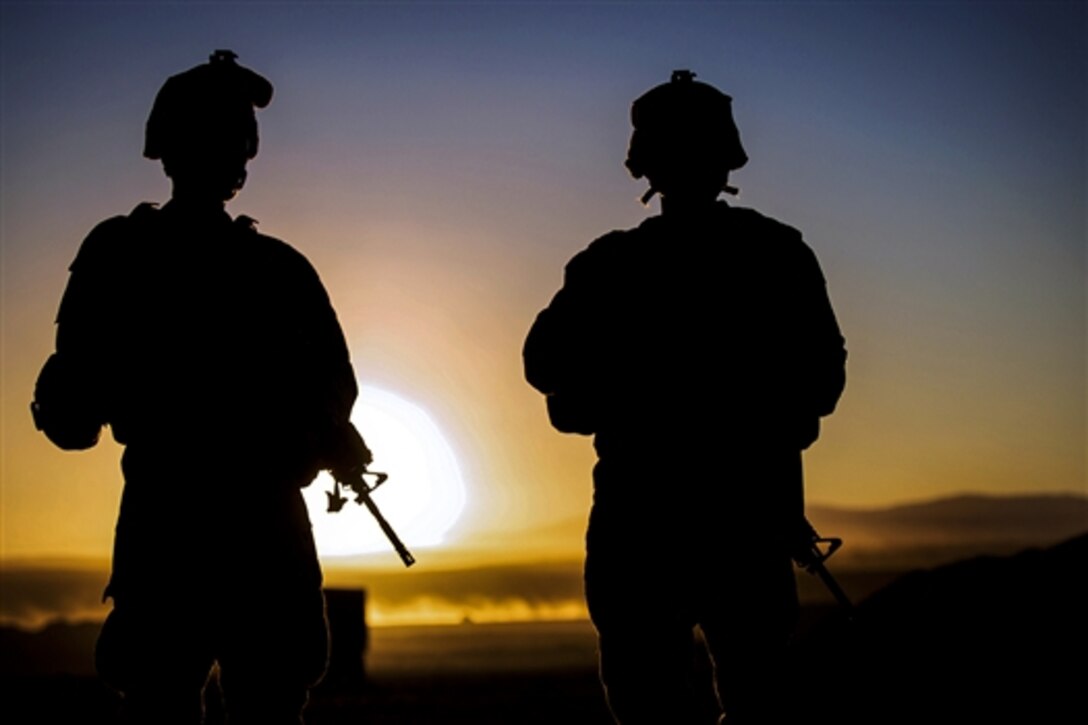 Marine Corps Lance Cpls. Joshua T. Turello, left, and Robert J. Young wait their turn to fire down range during a course on Camp Wilson at the Marine Corps Air Ground Combat Center in Twentynine Palms, Calif., Jan. 23, 2015. Turello and Young are motor transportation operators assigned to Headquarters Company, 4th Marine Regiment.