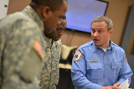 Staff Sergeants Adrian McLaughlin and Kehinde Ayeni discuss deployments for the Joint Task Force Empire Shield with FDNY EMT Capt. Joeseph Pataky Jan 26, 2015. 

