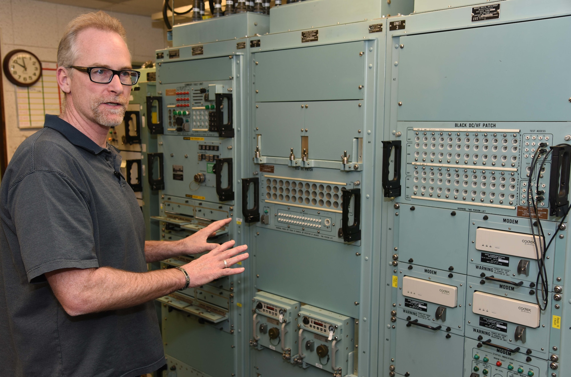 Bob Fick explains the functions of communications equipment in a launch control center trainer Jan. 20, 2015, at Malmstrom Air Force Base, Mont. Fick uses the trainer to familiarize 341st Missile Maintenance Squadron Airmen with how they will work in the missile field. Fick is a 341st Missile Maintenance Squadron missile satellite instructor. (U.S. Air Force photo/Airman 1st Class Dillon Johnston)