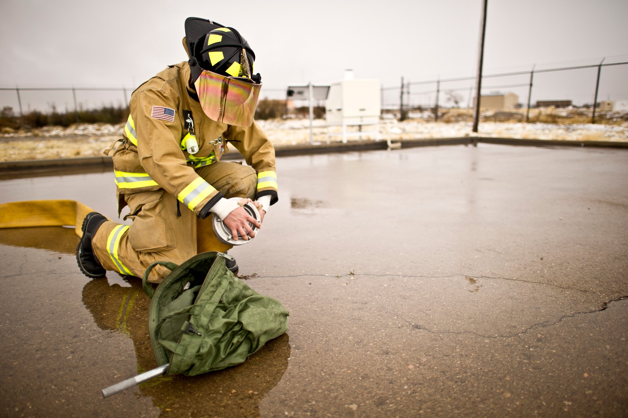 A member of the 49th Civil Engineering Squadron Fire Protection Flight conducts a damming, diking, and diverting operation with 5" fire hose in order to stop and redirect flow of the simulated Jet AA fuel during a POL fuel leak training exercise at Holloman Air Force Base, N.M., Jan. 22. Firefighters from the 49th CES performed a series of procedures to secure the area and maintain the simulated fire. (U.S. Air Force Staff by Sgt. Stacy Moless/Released)