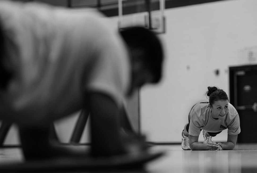 U.S. Air Force Staff Sgt. Cristina Sullivan, 633rd Force Support Squadron Back 2 Basics lead instructor, leads a group of Airmen in an abdominal workout during a B2B class at Langley Air Force Base, Va., Jan. 8, 2015. Sullivan said she has a passion for fitness and loves helping people who want to better themselves.  (U.S. Air Force photo by Senior Airman Kayla Newman/Released) 