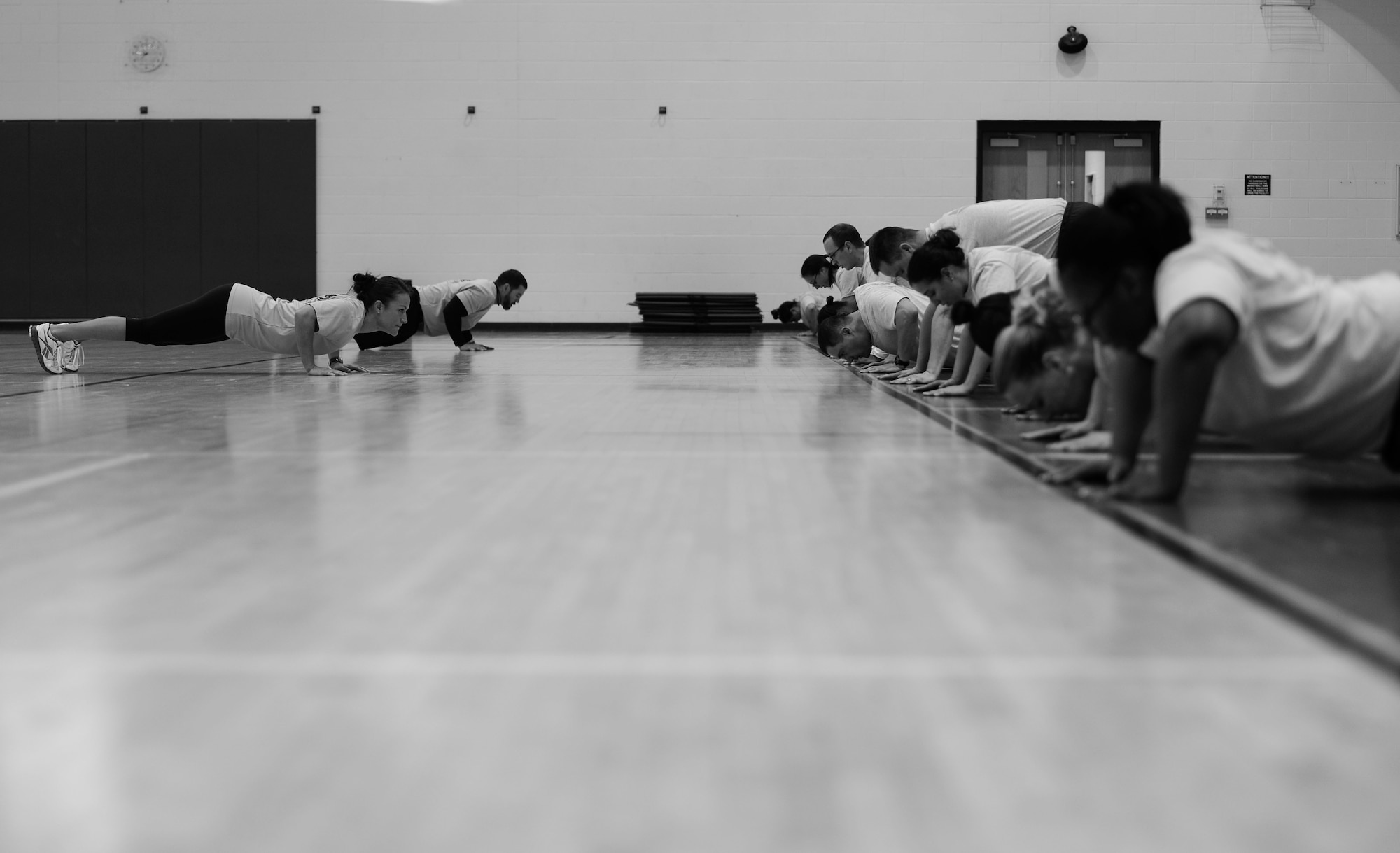 Participants in a Back 2 Basics course perform bodyweight exercises at Langley Air Force Base, Va., Jan. 8, 2015. During the eight-week course, participants are gradually given more challenging workouts to prevent their bodies from plateauing. (U.S. Air Force photo by Senior Airman Kayla Newman/Released) (Photo was cropped and levels were used to emphasize subject.)
