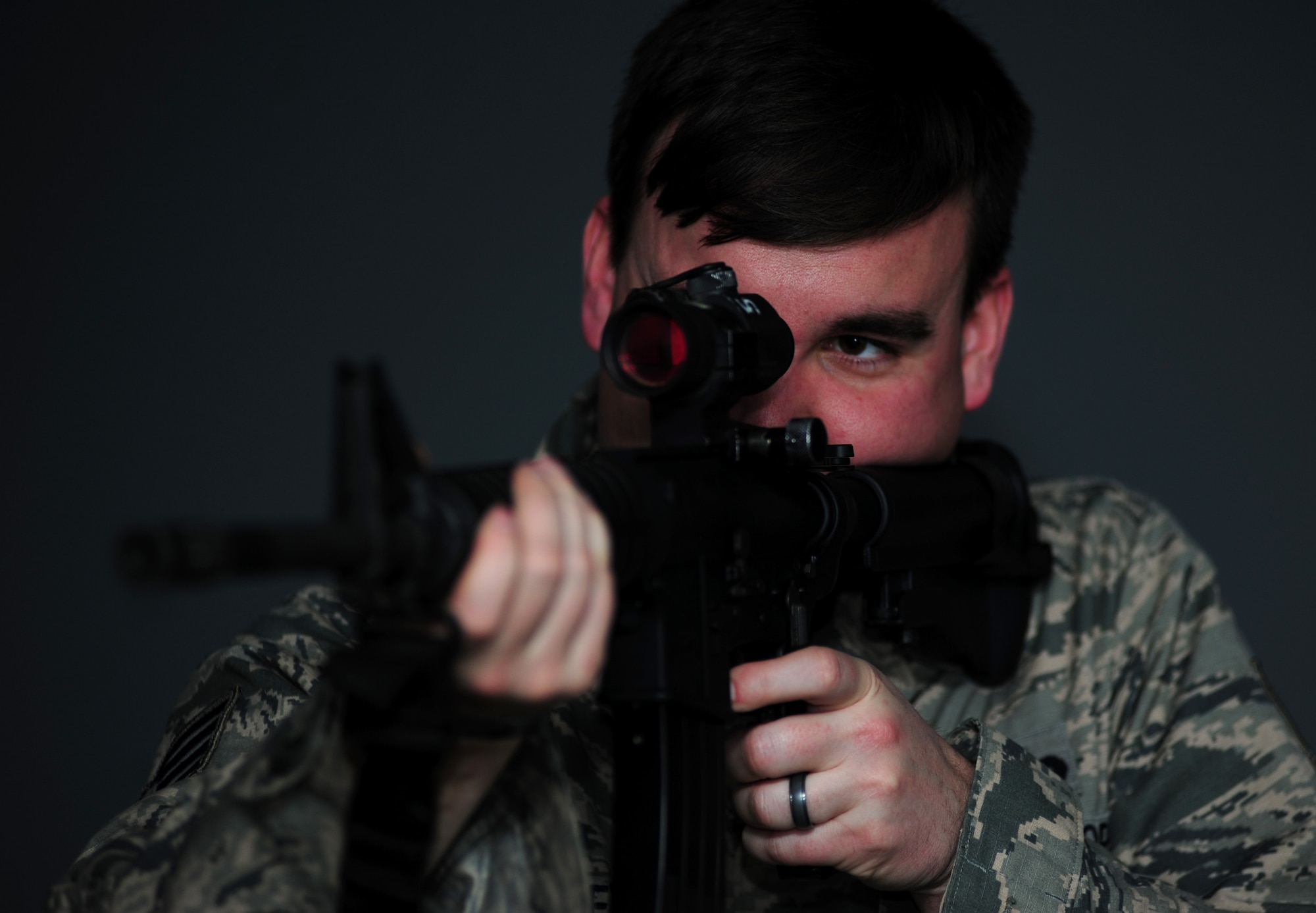 U.S. Air Force Staff Sgt. Ryan Gulley, 633rd Security Forces Squadron training instructor, fires at a simulated target at Langley Air Force Base, Va., Jan. 26, 2015. The new firearms simulator allows Airmen to gain real-world knowledge and experience through projections of real-life scenarios. (U.S. Air Force photo by Airman 1st Class Areca T. Wilson/Released) 