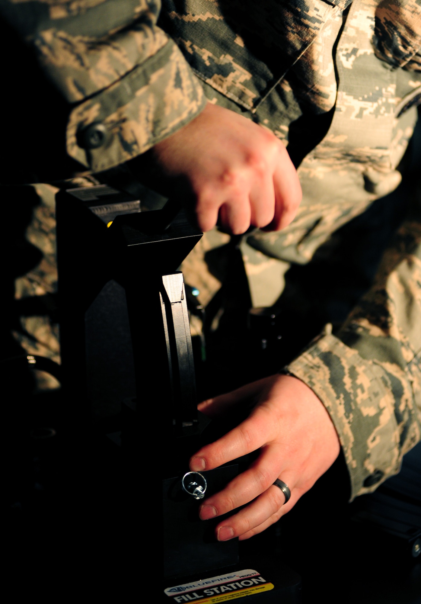 A U.S Air Force Airman refills a magazine replica with compressed air at Langley Air Force Base, Va., Jan. 26, 2015. The new firearms simulator uses compressed air, which feels more realistic by enabling Airmen to use their gear and reload their weapons as if they were on duty. (U.S. Air Force photo by Airman 1st Class Areca T. Wilson/Released) 