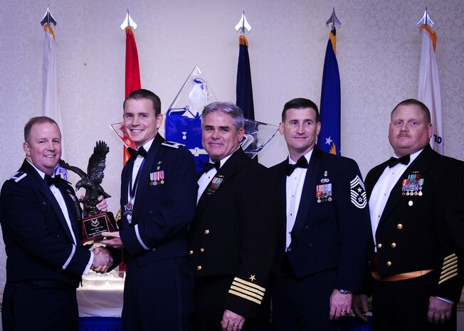 Col. Jeffrey DeVore, Joint Base Charleston commander, Capt. Timothy Sparks, JB Charleston deputy commander, Master Chief Petty Officer Joseph Gardner, Naval Support Activity command master chief and Chief Master Sgt. Mark Bronson, 628th Air Base Wing command chief present Capt. Joshua Van Wyngaarden, 628th Medical Operations Squadron, with the Company Grade Officer of the Year award Jan. 23, 2015, at the 2015 628th ABW Annual Awards Banquet at the Charleston Club on Joint Base Charleston, S.C. (U.S. Air Force photo/Airman 1st Class Clayton Cupit)