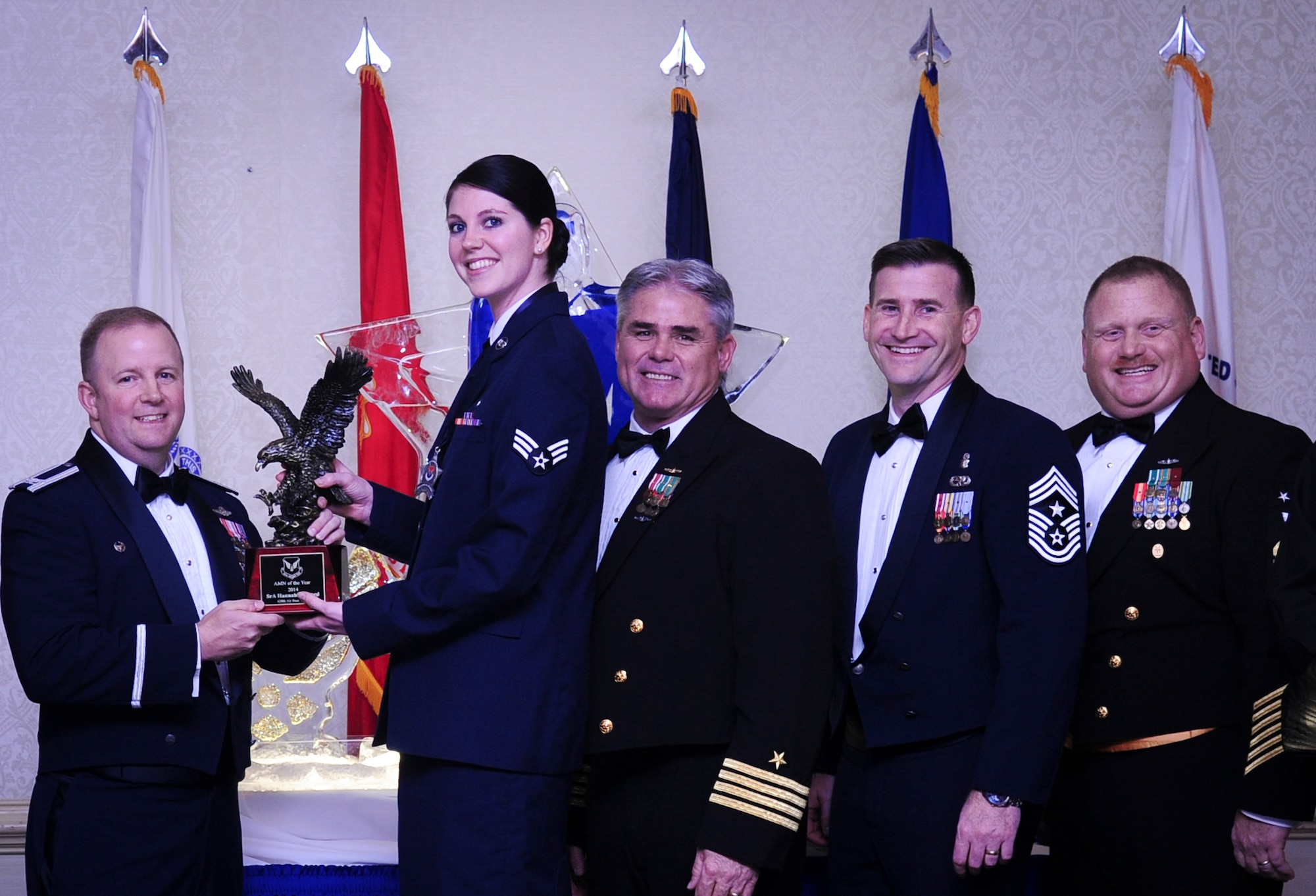 Col. Jeffrey DeVore, Joint Base Charleston commander, Capt. Timothy Sparks, JB Charleston deputy commander, Master Chief Petty Officer Joseph Gardner, Naval Support Activity command master chief and Chief Master Sgt. Mark Bronson, 628th Air Base Wing command chief present Senior Airman Hannah Leonard, 628th Aerospace Medicine Squadron, with the Airman of the Year award Jan. 23, 2015, at the 2015 628th ABW Annual Awards Banquet at the Charleston Club on Joint Base Charleston, S.C. (U.S. Air Force photo/Airman 1st Class Clayton Cupit)