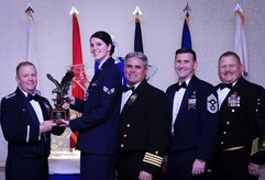 Col. Jeffrey DeVore, Joint Base Charleston commander, Capt. Timothy Sparks, JB Charleston deputy commander, Master Chief Petty Officer Joseph Gardner, Naval Support Activity command master chief and Chief Master Sgt. Mark Bronson, 628th Air Base Wing command chief present Senior Airman Hannah Leonard, 628th Aerospace Medicine Squadron, with the Airman of the Year award Jan. 23, 2015, at the 2014 628th ABW Annual Awards Banquet at the Charleston Club on Joint Base Charleston, S.C. (U.S. Air Force photo/Airman 1st Class Clayton Cupit) 
