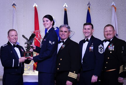 Col. Jeffrey DeVore, Joint Base Charleston commander, Capt. Timothy Sparks, JB Charleston deputy commander, Master Chief Petty Officer Joseph Gardner, Naval Support Activity command master chief and Chief Master Sgt. Mark Bronson, 628th Air Base Wing command chief present Senior Airman Hannah Leonard, 628th Aerospace Medicine Squadron, with the Airman of the Year award Jan. 23, 2015, at the 2015 628th ABW Annual Awards Banquet at the Charleston Club on Joint Base Charleston, S.C. (U.S. Air Force photo/Airman 1st Class Clayton Cupit)