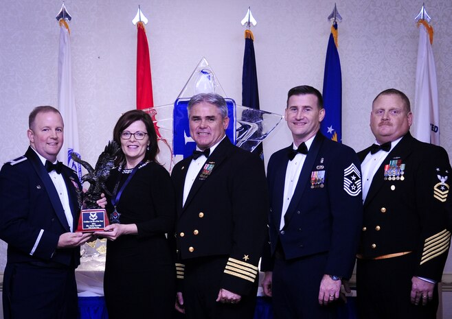 Col. Jeffrey DeVore, Joint Base Charleston commander, Capt. Timothy Sparks, JB Charleston deputy commander, Master Chief Petty Officer Joseph Gardner, Naval Support Activity command master chief and Chief Master Sgt. Mark Bronson, 628th Air Base Wing command chief present Ms. Anna Urrutia, 628th Contracting Squadron, with the Civilian Category III of the Year award Jan. 23, 2015, at the 2015 628th ABW Annual Awards Banquet at the Charleston Club on Joint Base Charleston, S.C. (U.S. Air Force photo/Airman 1st Class Clayton Cupit)