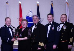 Col. Jeffrey DeVore, Joint Base Charleston commander, Capt. Timothy Sparks, JB Charleston deputy commander, Master Chief Petty Officer Joseph Gardner, Naval Support Activity command master chief and Chief Master Sgt. Mark Bronson, 628th Air Base Wing command chief present Ms. Catherine Hallett, 628th Medical Operations Squadron, with the Civilian Category II of the Year award Jan. 23, 2015, at the 2014 628th ABW Annual Awards Banquet at the Charleston Club on Joint Base Charleston, S.C. (U.S. Air Force photo/Airman 1st Class Clayton Cupit)