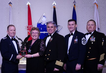 Col. Jeffrey DeVore, Joint Base Charleston commander, Capt. Timothy Sparks, JB Charleston deputy commander, Master Chief Petty Officer Joseph Gardner, Naval Support Activity command master chief and Chief Master Sgt. Mark Bronson, 628th Air Base Wing command chief present Ms. Catherine Hallett, 628th Medical Operations Squadron, with the Civilian Category II of the Year award Jan. 23, 2015, at the 2015 628th ABW Annual Awards Banquet at the Charleston Club on Joint Base Charleston, S.C. (U.S. Air Force photo/Airman 1st Class Clayton Cupit)