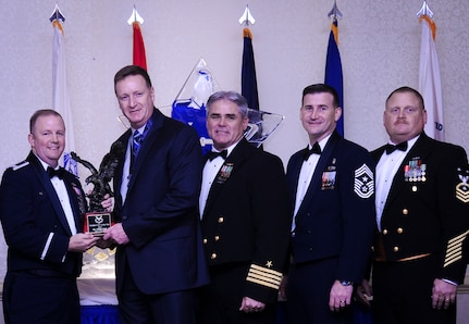 Col. Jeffrey DeVore, Joint Base Charleston commander, Capt. Timothy Sparks, JB Charleston deputy commander, Master Chief Petty Officer Joseph Gardner, Naval Support Activity command master chief and Chief Master Sgt. Mark Bronson, 628th Air Base Wing command chief present Mr. Phillip Hull, 628th Security Forces Squadron, with the Civilian Category I of the Year award Jan. 23, 2015, at the 2015 628th ABW Annual Awards Banquet at the Charleston Club on Joint Base Charleston, S.C. (U.S. Air Force photo/Airman 1st Class Clayton Cupit)