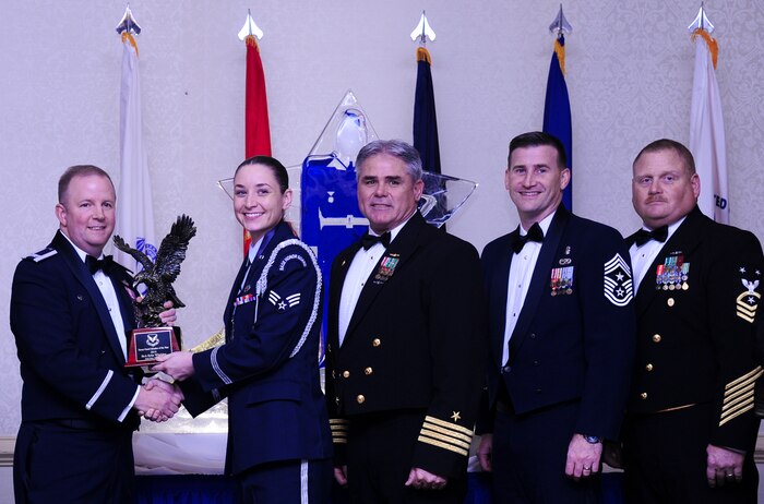 Col. Jeffrey DeVore, Joint Base Charleston commander, Capt. Timothy Sparks, JB Charleston deputy commander, Master Chief Petty Officer Joseph Gardner, Naval Support Activity command master chief and Chief Master Sgt. Mark Bronson, 628th Air Base Wing command chief present Senior Airman Erin Winkler, 437th Aircraft Maintenance Squadron, with the Honor Guard Member of the Year award Jan. 23, 2015, at the 2015 628th ABW Annual Awards Banquet at the Charleston Club on Joint Base Charleston, S.C. (U.S. Air Force photo/Airman 1st Class Clayton Cupit)