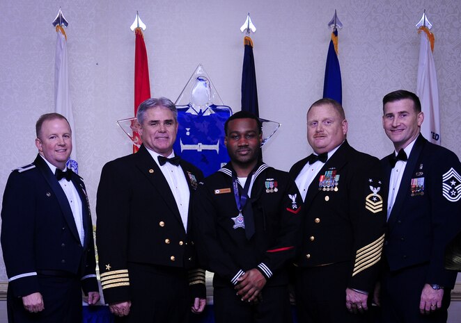 Col. Jeffrey DeVore, Joint Base Charleston commander, Capt. Timothy Sparks, JB Charleston deputy commander, Master Chief Petty Officer Joseph Gardner, Naval Support Activity command master chief and Chief Master Sgt. Mark Bronson, 628th Air Base Wing command chief stand with Logistics Specialist 3rd Class Delmetrius Blanding, NSA, Blue Jacket of the Year, Jan. 23, 2015, at the 2015 628th ABW Annual Awards Banquet at the Charleston Club on Joint Base Charleston, S.C. (U.S. Air Force photo/Airman 1st Class Clayton Cupit)