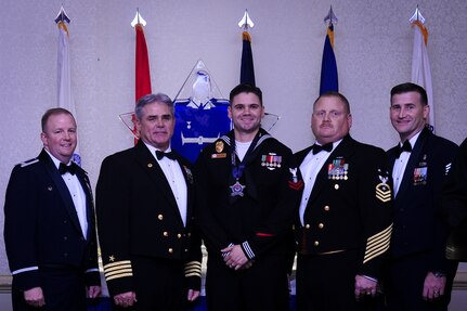 Col. Jeffrey DeVore, Joint Base Charleston commander, Capt. Timothy Sparks, JB Charleston deputy commander, Master Chief Petty Officer Joseph Gardner, Naval Support Activity command master chief and Chief Master Sgt. Mark Bronson, 628th Air Base Wing command chief stand with Master at Arms 2nd Class Brian Cobb, NSA, Junior Sailor of the Year, Jan. 23, 2015, at the 2015 628th ABW Annual Awards Banquet at the Charleston Club on Joint Base Charleston, S.C. (U.S. Air Force photo/Airman 1st Class Clayton Cupit)