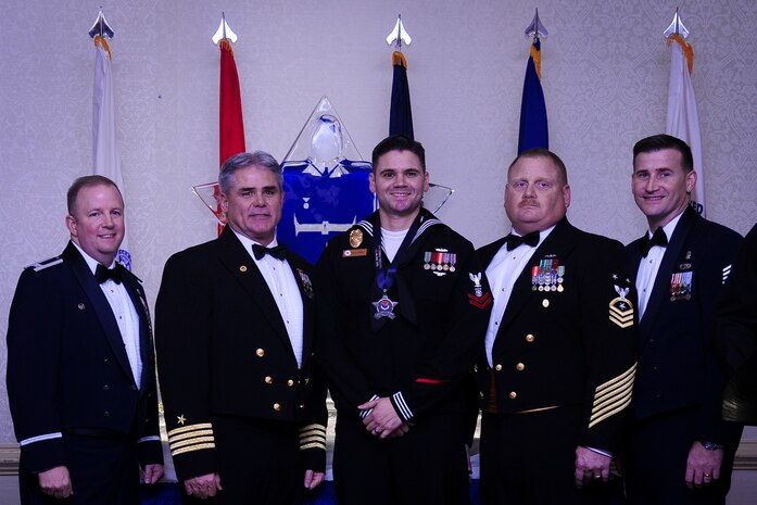 Col. Jeffrey DeVore, Joint Base Charleston commander, Capt. Timothy Sparks, JB Charleston deputy commander, Master Chief Petty Officer Joseph Gardner, Naval Support Activity command master chief and Chief Master Sgt. Mark Bronson, 628th Air Base Wing command chief stand with Master at Arms 2nd Class Brian Cobb, NSA, Junior Sailor of the Year, Jan. 23, 2015, at the 2015 628th ABW Annual Awards Banquet at the Charleston Club on Joint Base Charleston, S.C. (U.S. Air Force photo/Airman 1st Class Clayton Cupit)