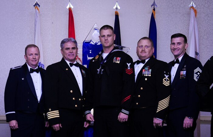 Col. Jeffrey DeVore, Joint Base Charleston commander, Capt. Timothy Sparks, JB Charleston deputy commander, Master Chief Petty Officer Joseph Gardner, Naval Support Activity command master chief and Chief Master Sgt. Mark Bronson, 628th Air Base Wing command chief stand with Master at Arms 1st Class Mark VanWyck, NSA, Senior Sailor of the Year, Jan. 23, 2015, at the 2015 628th ABW Annual Awards Banquet at the Charleston Club on Joint Base Charleston, S.C. (U.S. Air Force photo/Airman 1st Class Clayton Cupit)
