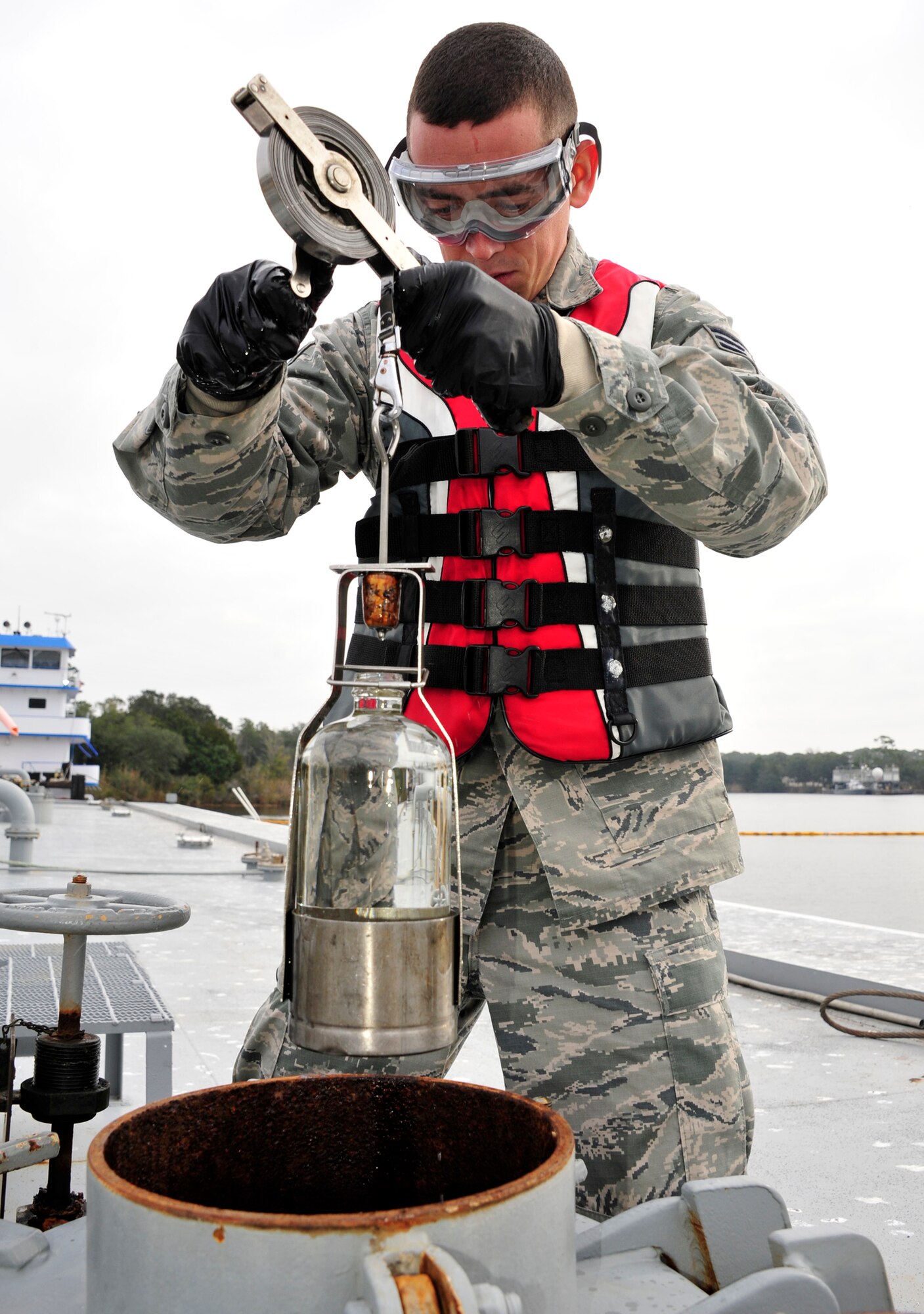 Senior Airman Samuel Fallon, of the 96th Logistics Readiness Squadron, performs an all-level fuel sample of the main tank of a fuel barge at the Weekly Bayou fuel ramp on Eglin Air Force Base, Fla., Jan. 15.  The fuels laboratory technicians perform this to capture the content of the barge tank at each level.  The fuel samples are tested in the fuel laboratory and also shipped out for further testing.  The 96th Fuels Management Flight provides fuel support to all Eglin units and manages the requisition, receipt, storage, issue, quality and accounting of all petroleum and cryogenic products here.