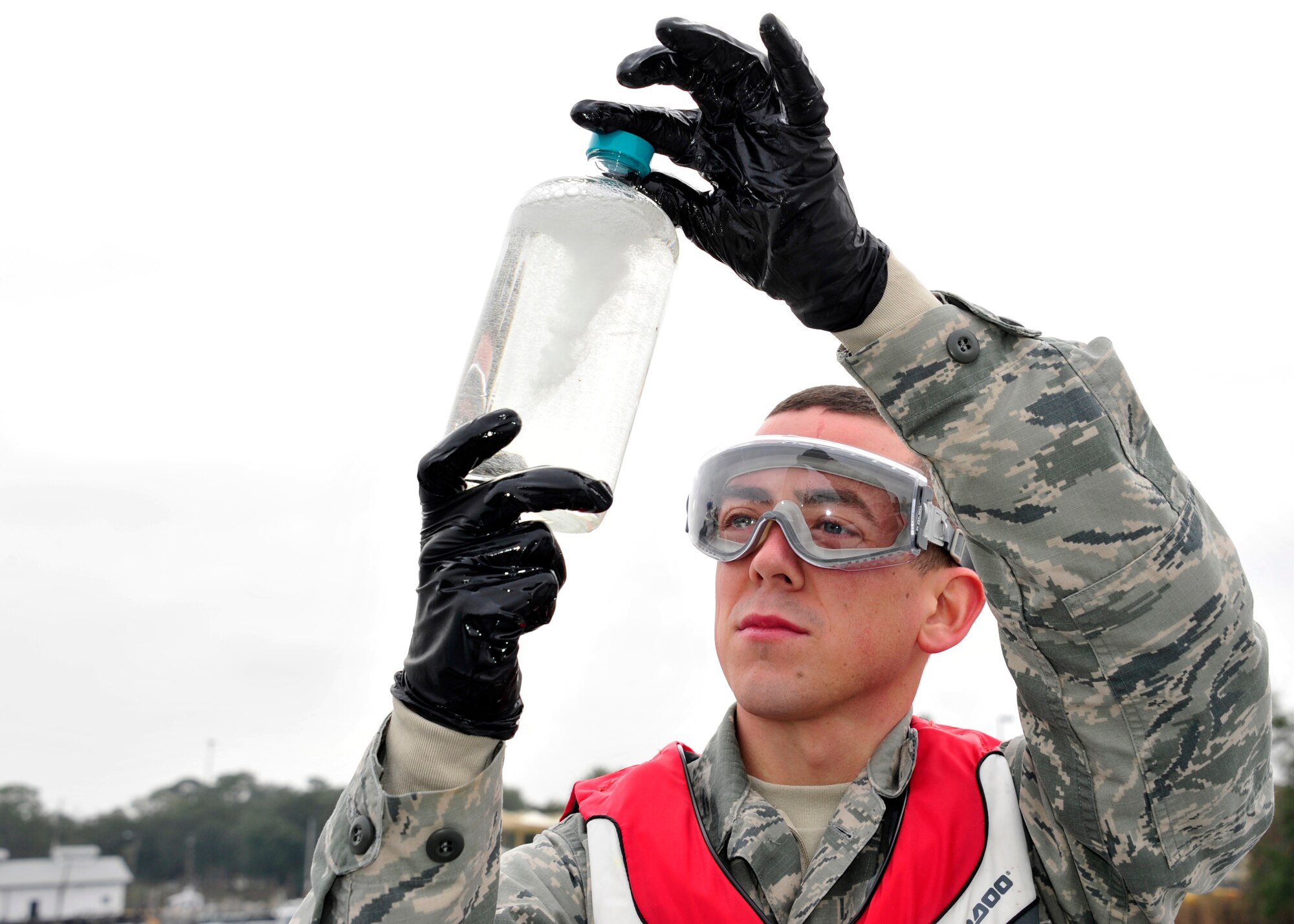 Senior Airman Samuel Fallon, of the 96th Logistics Readiness Squadron, performs a visual analysis of a fuel sample from a fuel barge at the Weekly Bayou fuel ramp on Eglin Air Force Base, Fla., Jan 15. The fuels laboratory technicians swirl the sample bottle to look for color, suspended particles, and water in the fuel.  The 96th Fuels Management Flight provides fuel support to all Eglin units and manages the requisition, receipt, storage, issue, quality and accounting of all petroleum and cryogenic products here.