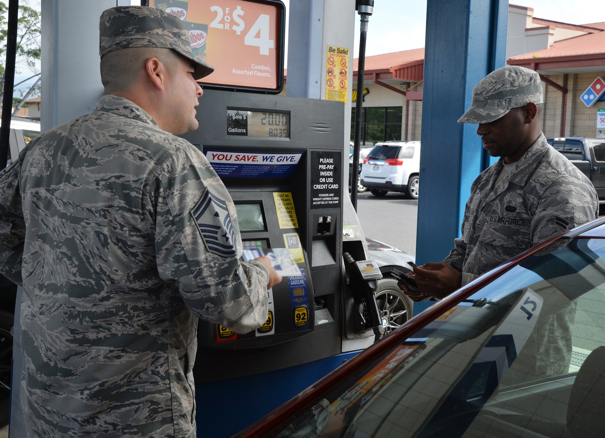 Senior Master Sgt. Jessie Castillo, U.S. Pacific Command Joint Intelligence Operations Center Air Force Element first sergeant, gives an AAFES gift card to a shoppette customer during a surprise Air Force Hawaii First Sergeants Association AAFES gift card giveaway event at Joint Base Pearl Harbor-Hickam, Hawaii, Jan. 23rd, 2015. The event was a way for the association to give back to joint base members after their successful Operation Warmheart fundraiser campaign last year, providing the first sergeants an opportunity to give pump gas for customers and give away $25 AAFES gift cards. (U.S. Air Force photo by Staff Sgt. Alexander Martinez)