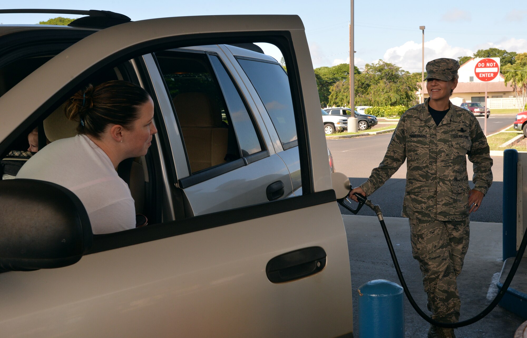 Master Sgt. Tina Timmerman, 613th Air Operations Center first sergeant, pumps gas for a shoppette customer during a surprise Air Force Hawaii First Sergeants Association AAFES gift card giveaway event at Joint Base Pearl Harbor-Hickam, Hawaii, Jan. 23rd, 2015. The event was a way for the association to give back to joint base members after their successful Operation Warmheart fundraiser campaign last year, providing the first sergeants an opportunity to give pump gas for customers and give away $25 AAFES gift cards. (U.S. Air Force photo by Staff Sgt. Alexander Martinez)