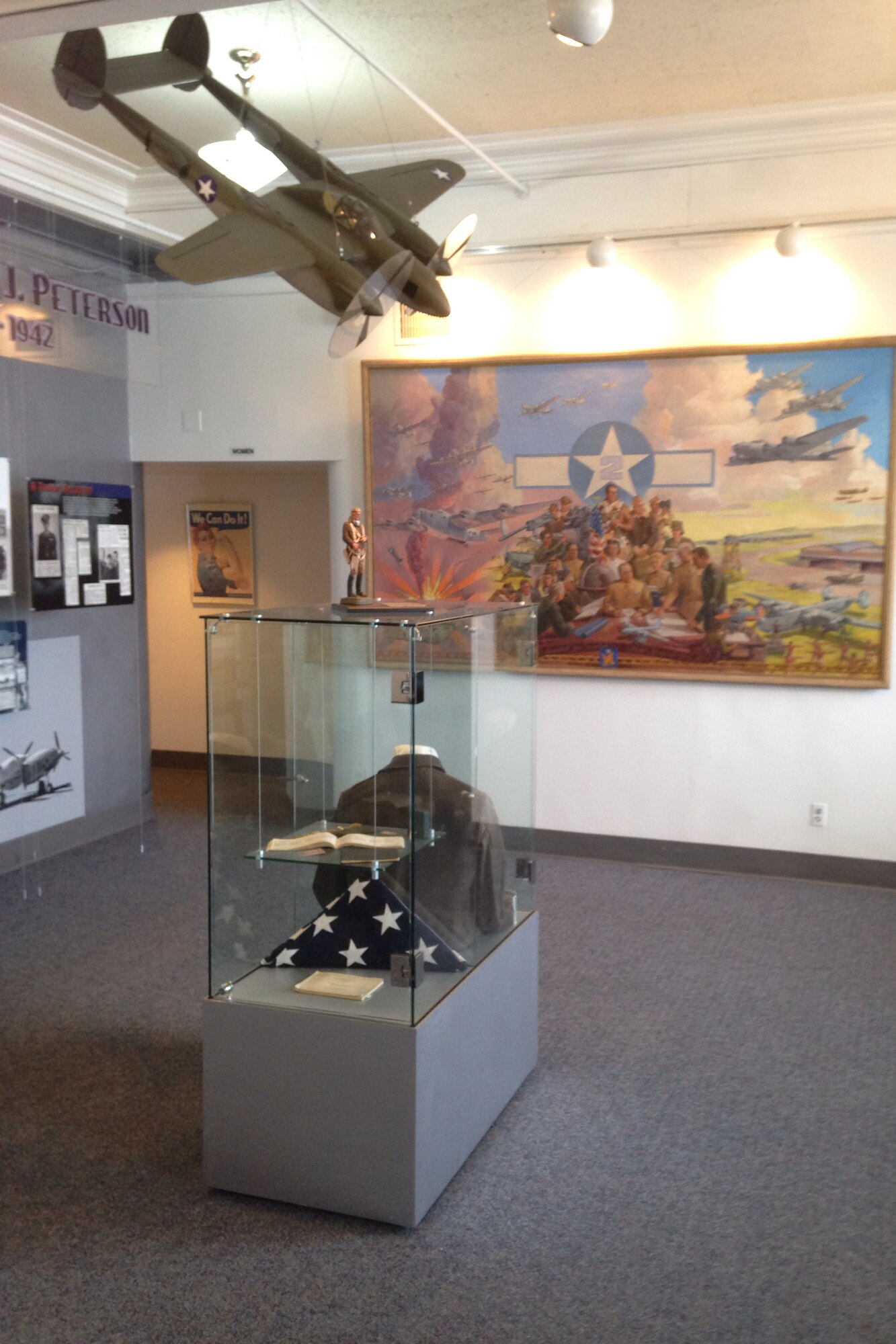 PETERSON AIR FORCE BASE, Colo. -- A P-38 Lightning is poised to strike above some of the World War II artifacts found in the terminal building of the Peterson Air and Space Museum. Displays found in the building tell the story of Peterson Field and its involvement in World War II. (U.S. Air Force photo by Dave Smith)