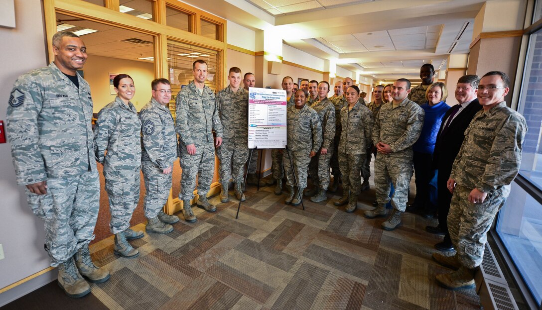 Col. Ty Neuman, 28th Bomb Wing vice commander (center), recognizes volunteers for their support of the base Unit Tax Center during its grand opening at the Rushmore Center on Ellsworth Air Force Base, S.D., Jan. 23, 2015. Active-duty Airmen, retirees and family members can now file their 2014 taxes for free at the base tax center. (U.S. Air Force photo by Senior Airman Zachary Hada/Released)
