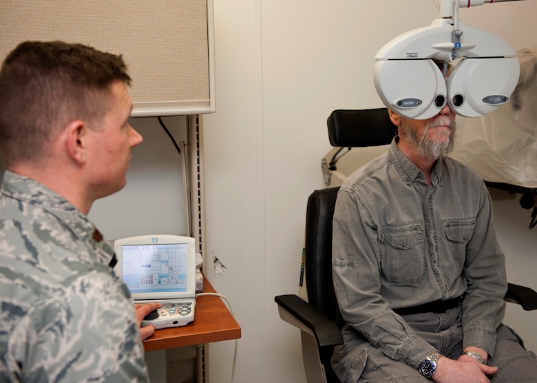 PETERSON AIR FORCE BASE, Colo. – Gordan Dixon, an optometry patient, gets his eyes checked by Maj. Chad Willis, 21st Aerospace Medical Squadron chief of aerospace optometry at the optometry clinic, Jan. 16, 2015. The optometry clinic ensures active-duty personnel are visually qualified for worldwide assignment and for the performance of their Air Force job. The optometry clinic is now in the temporary facility next to building 959, the main clinic. (U.S. Air Force photo by Senior Airman Tiffany DeNault)