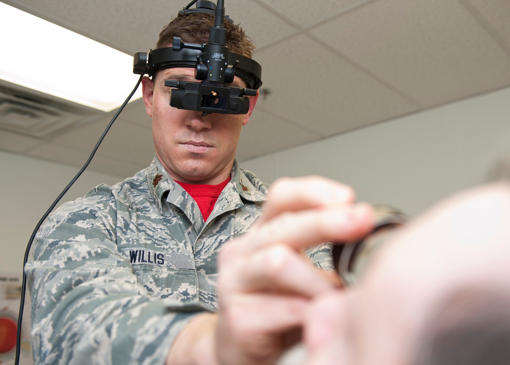 PETERSON AIR FORCE BASE, Colo. – Maj. Chad Willis, 21st Aerospace Medical Squadron chief of aerospace optometry, looks into the back of Gordan Dixon’s eye, a patient at the optometry clinic, Jan. 16, 2015. The optometry clinic ensures active-duty personnel are visually qualified for worldwide assignment and for the performance of their Air Force job. The optometry clinic is now in the temporary facility next to building 959, the main clinic. (U.S. Air Force photo by Senior Airman Tiffany DeNault)