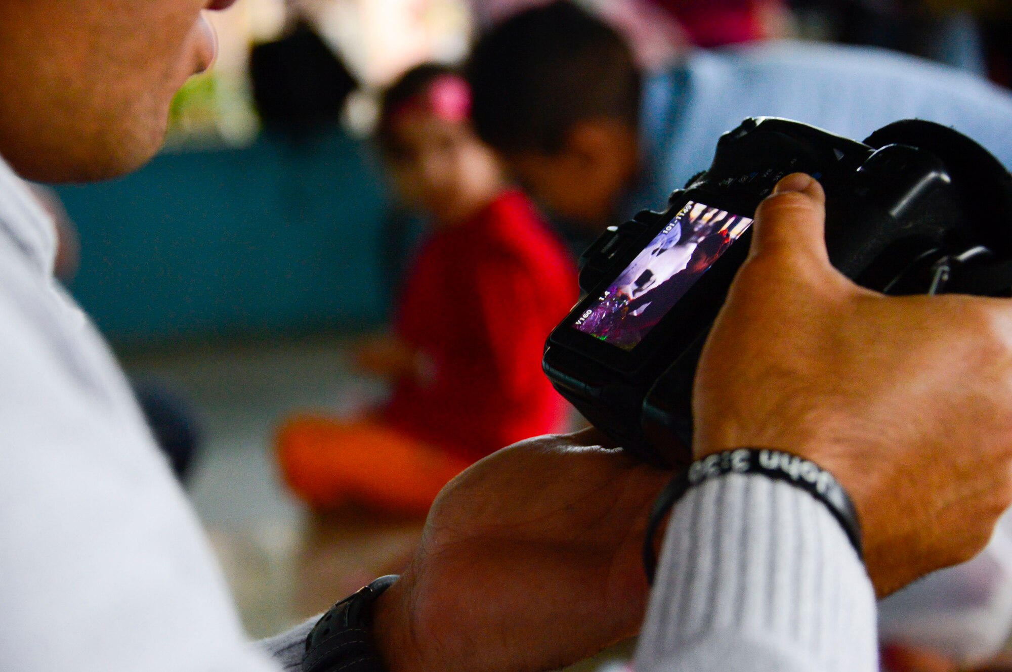 U.S. Air Force Tech. Sgt. Keola Soon, assigned to the 612th Air Base Squadron, looks at a photo he took during Joint Task Force-Bravo’s visit to at the Sisters of Charity Orphanage in Comayagua, Honduras, Jan. 25, 2015. The Sisters of Charity Orphanage is one of seven different orphanages from around the Comayagua Valley that the U.S. military personnel assigned to JTF-Bravo have supported over the past 17 years. In addition to spending time with interacting with children, members have also collected and donated much-needed supplies and food, as well as helped in minor construction work on the buildings in which the children live. (U.S. Air Force photo/Tech. Sgt. Heather Redman)