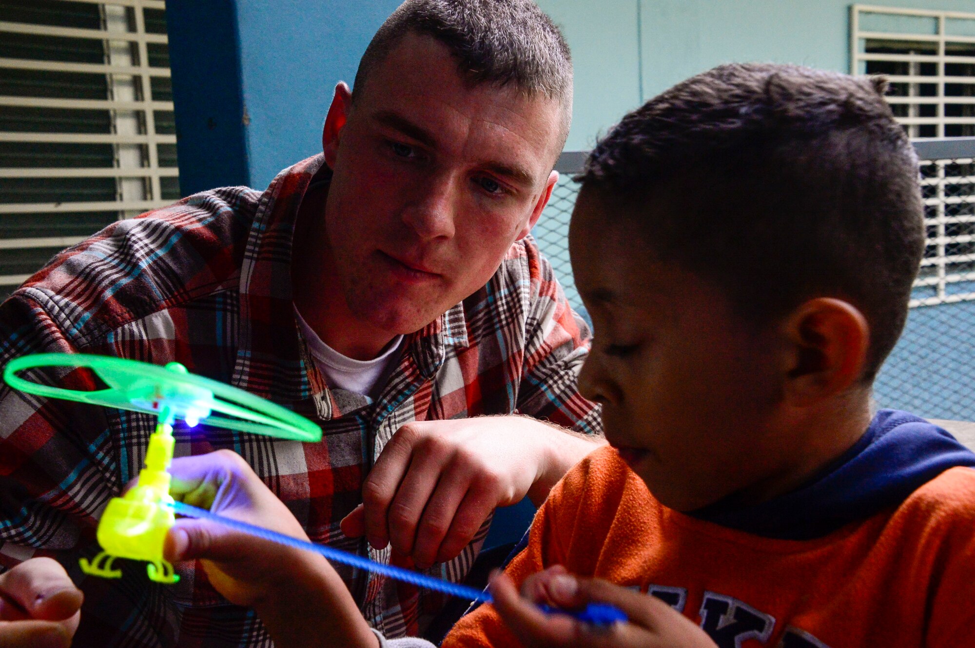 U.S. Marine Corps 1st Lt. Ryan Lee, assigned to Marine Corps Forces Southern, helps a young boy with a toy during Joint Task Force-Bravo’s visit to at the Sisters of Charity Orphanage in Comayagua, Honduras, Jan. 25, 2015. The Sisters of Charity Orphanage is one of seven different orphanages from around the Comayagua Valley that the U.S. military personnel assigned to JTF-Bravo have supported over the past 17 years. In addition to spending time with interacting with children, members have also collected and donated much-needed supplies and food, as well as helped in minor construction work on the buildings in which the children live. (U.S. Air Force photo/Tech. Sgt. Heather Redman)