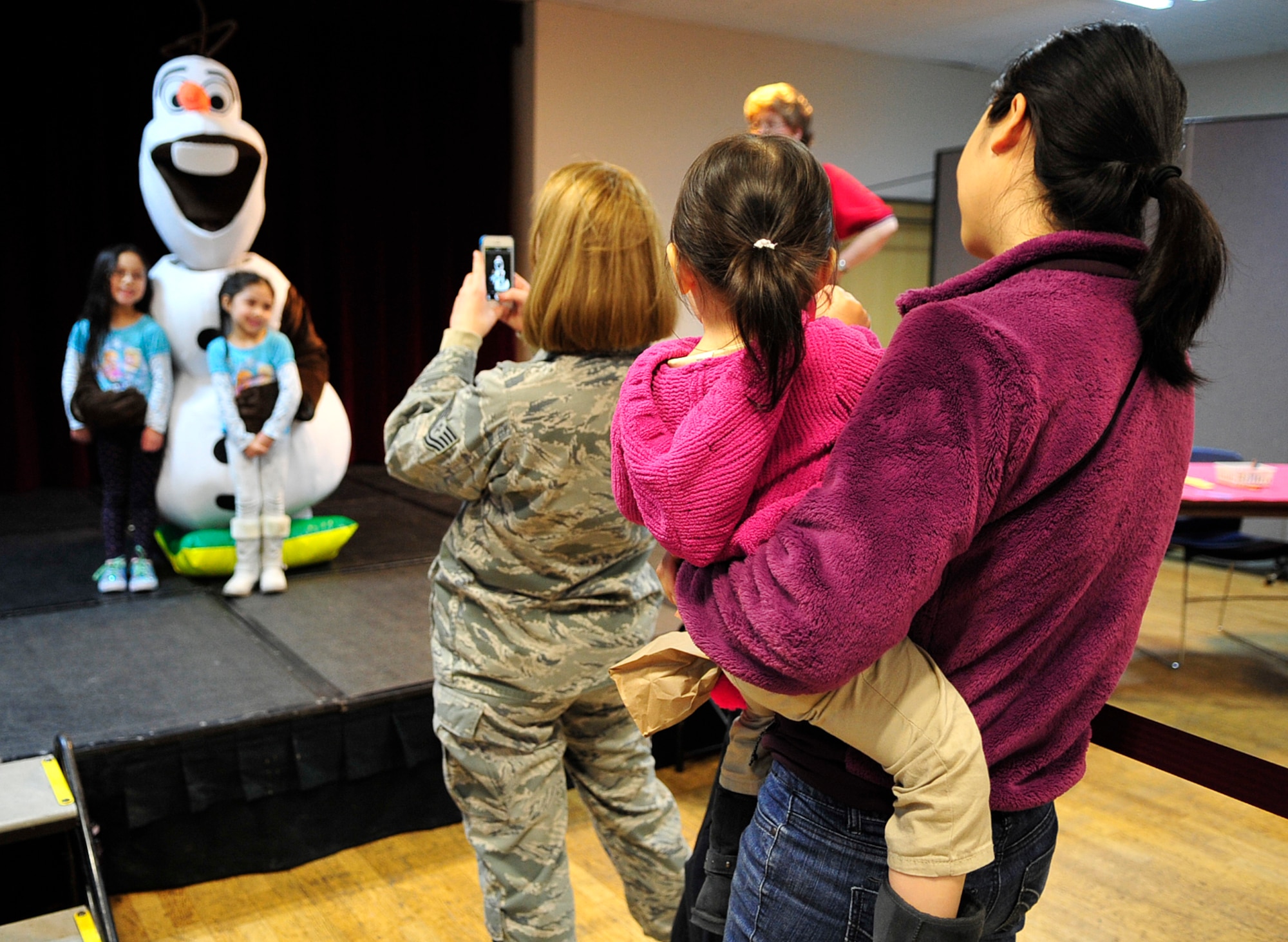 Children and families pose for photos with Olaf during the “Frozen” family event, Jan. 26, 2015 at the Ramstein Community Center on Ramstein Air Base, Germany. Children and their families had the opportunity to meet one of the movie’s characters, Olaf, as well as make arts and crafts, play in a bouncy house and take home balloon animals. (U.S. Air Force photo/Airman 1st Class Larissa Greatwood)